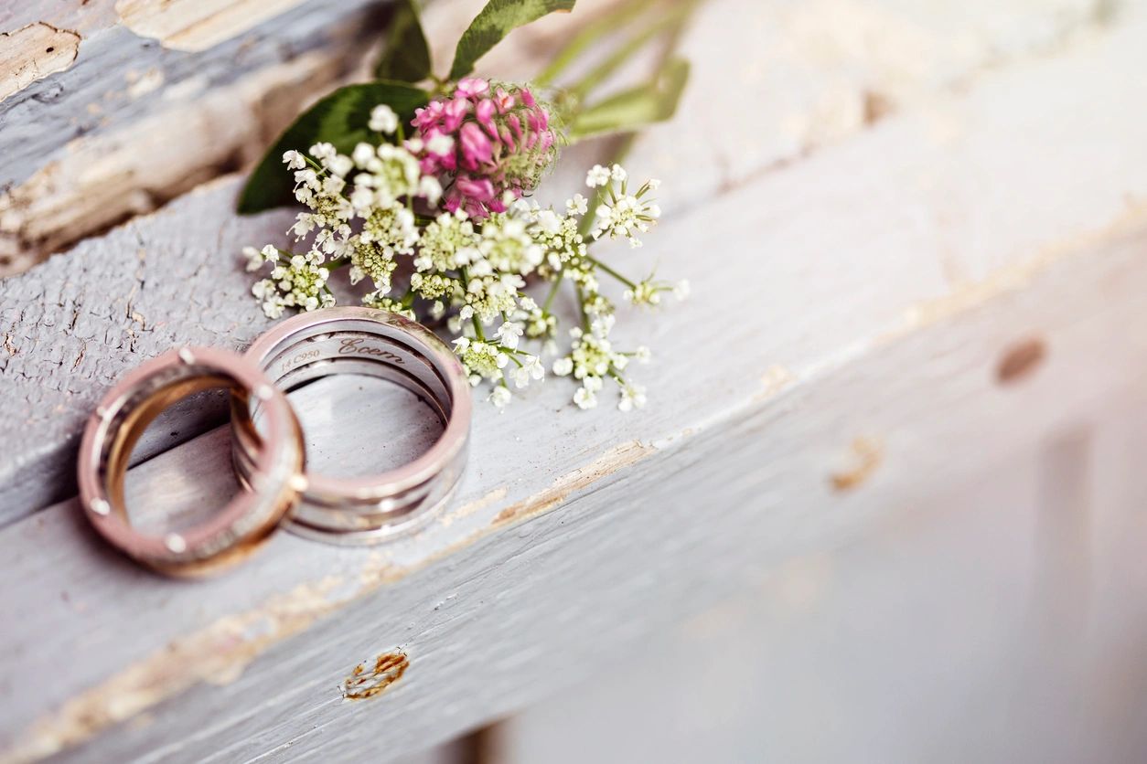A close-up of the couple engagement rings and flowers